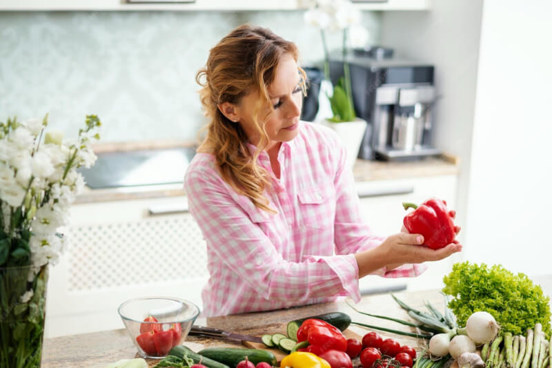 Femme mature préparant un repas léger et équilibré pour perdre du poids sans fatigue